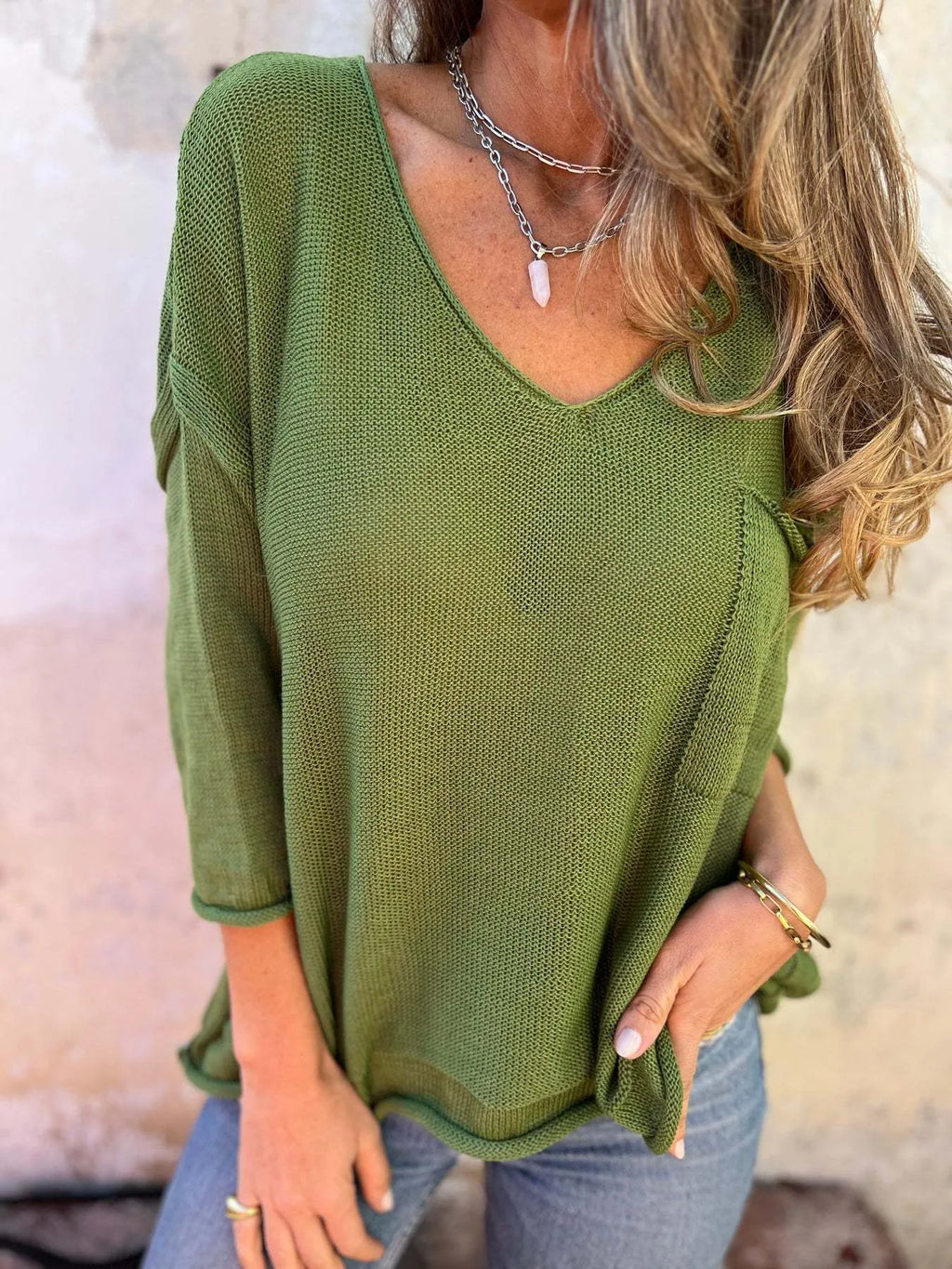 Woman wearing a green sweater with a neutral background